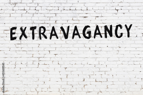 Inscription extravagancy painted on white brick wall photo