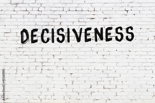 Inscription decisiveness painted on white brick wall photo