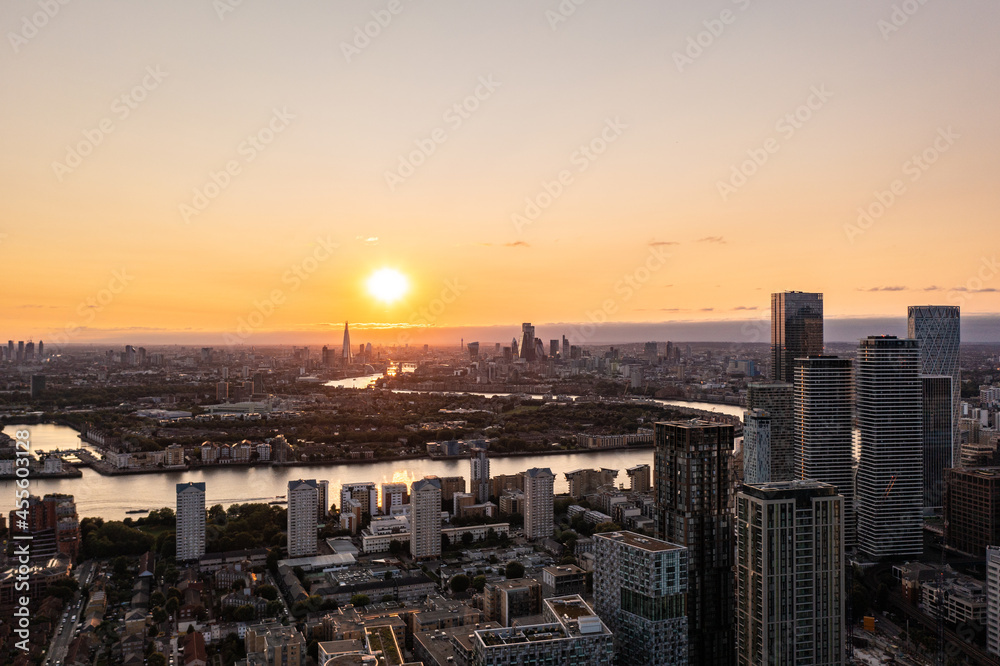 Panoramic aerial skyline view of east London at sunrise with skyscrapers of Canary Wharf and beautiful colorful sky at background