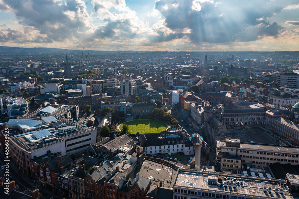 Aerial view of Dublin skyline with stadium, playground and residential and commercial buildings under a cloudy sky during sunset