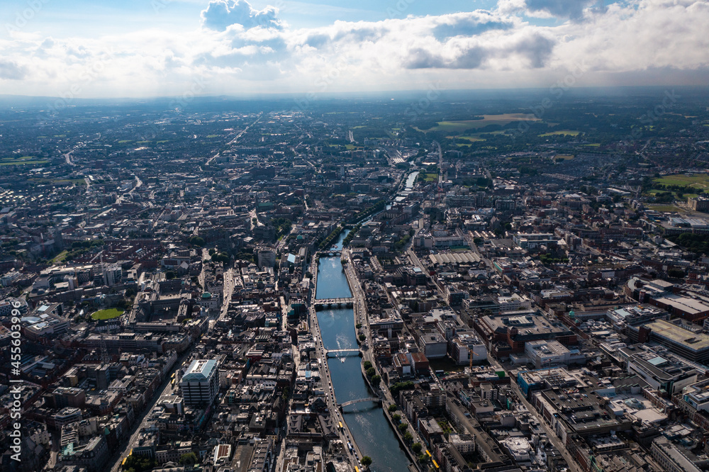 Aerial view of skyline of Dublin with river flowing with bridge connecting two sides of street surrounded by buildings during a cloudy day Aerial view of skyline of Dublin with river flowing with bridge connecting two sides of street surrounded by buildings during a cloudy day
