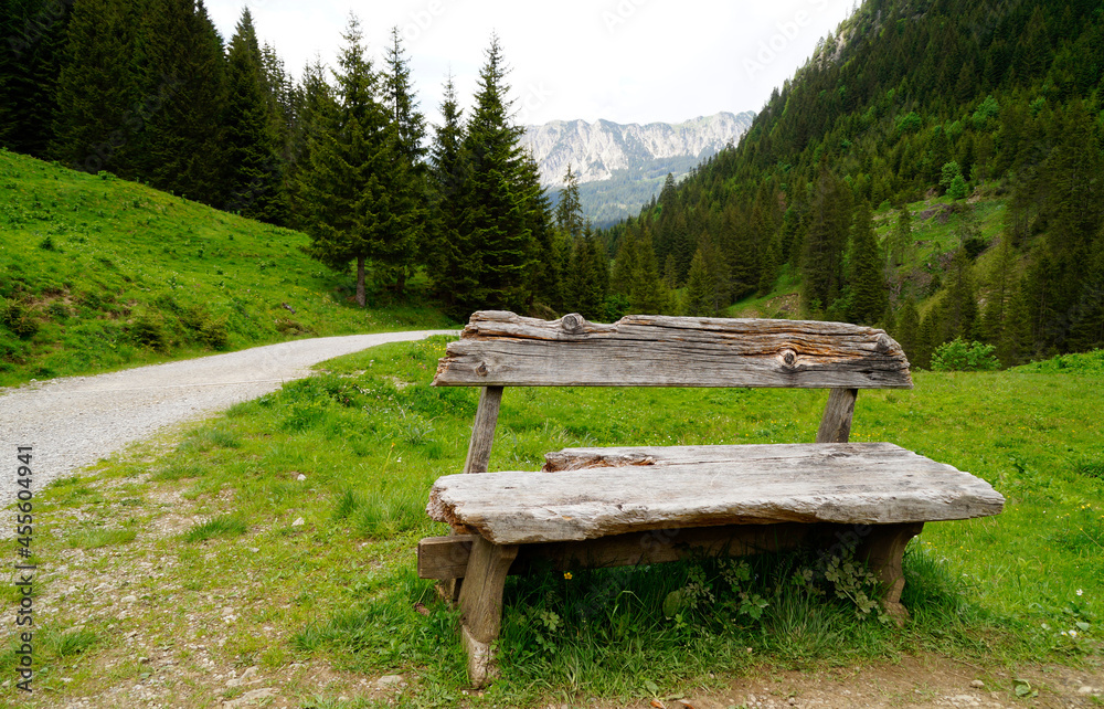 beautiful view of an old wooden bench and a hiking trail leading to the picturesque Edenbachalpe in the Tannheim Valley or Tannheimer Tal ot Tannheim, Austria