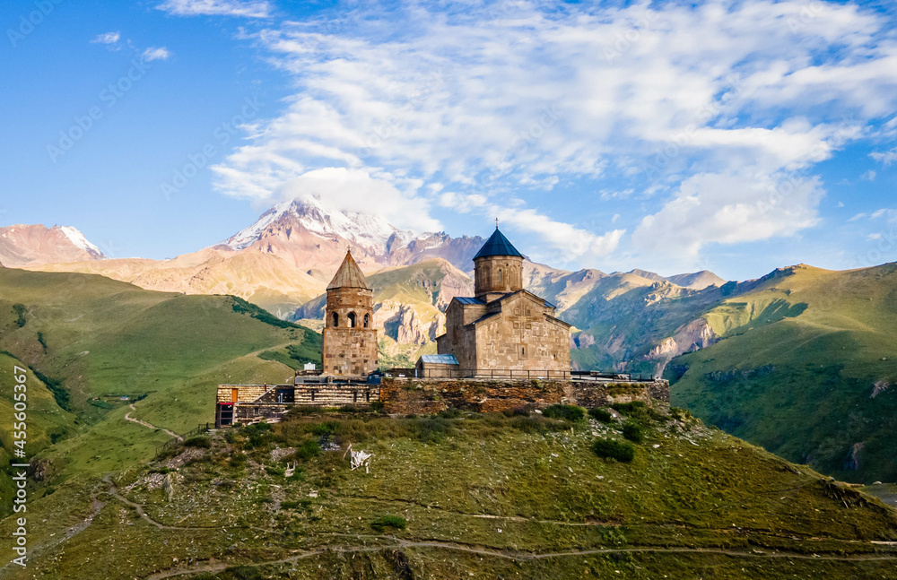 Aerial close up view of Kazbek mountain and Gergeti Trinity Church in Georgia at sunrise
