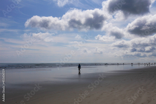 People walking on beach on a cloudy day