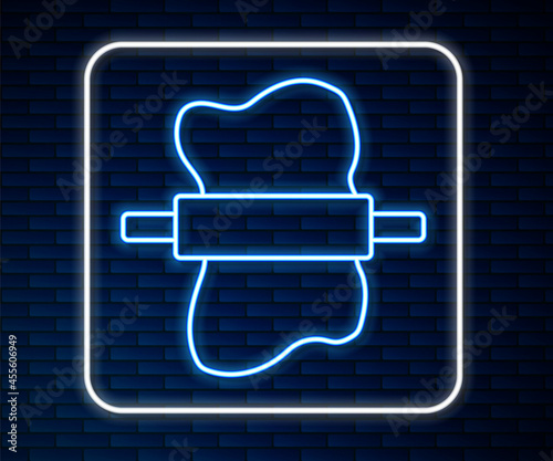 Glowing neon line Rolling pin on dough icon isolated on brick wall background. Vector