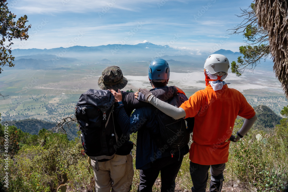 A group of young travelers are walking along a trail in the mountains