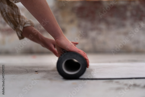 Woman hands rolled up yoga mat on gym floor in yoga fitness training room