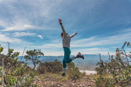woman jumping over rocks in mountain