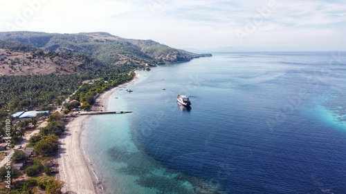 Aerial view of turquoise water ocean, coral reefs and passenger ferry on tropical Atauro Island in Timor Leste, Southeast Asia photo