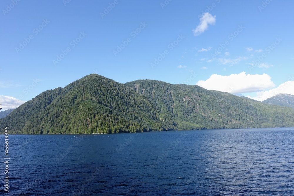 Majestic views of the forested mountains and beautiful blue ocean along the british columbia coast along the BC ferries inside passage route, on a beautiful sunny day