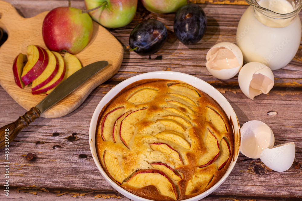 Homemade apple pie. There are apples, milk and apple pie on a wooden background. Homemade apple pie. There are apples, milk and apple pie on a wooden background.