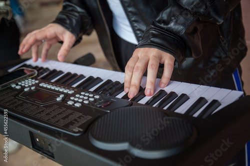 A man plays a synthesizer in close-up. Hands playing the synthesizer close-up.