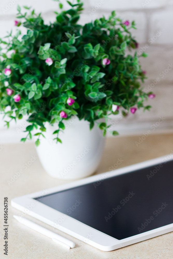White tablet on the table, blurred background White tablet on the table, blurred background