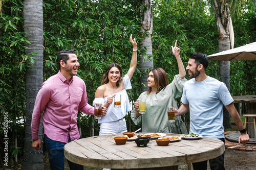 Canvas Print Group of Young latin Friends Meeting For beer, michelada Drinks And mexican Food