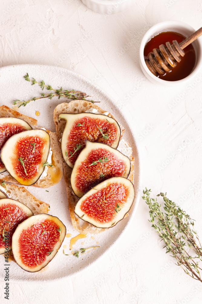 Breakfast with sweet bruschettas with figs and honey on a white plate Breakfast with sweet bruschettas with figs and honey on a white plate