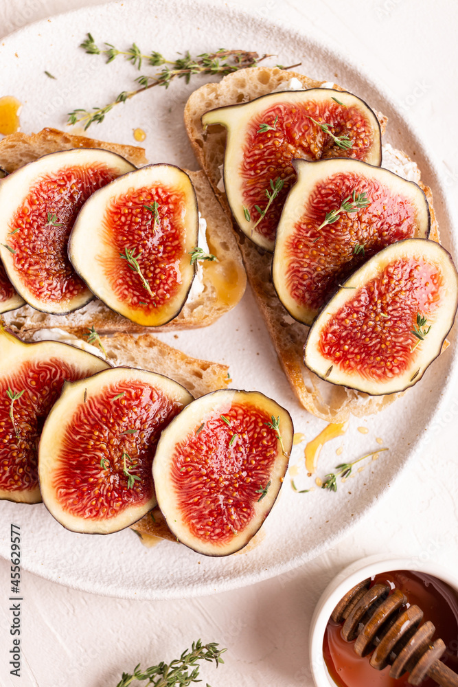 Breakfast with sweet bruschettas with figs and honey on a white plate Breakfast with sweet bruschettas with figs and honey on a white plate