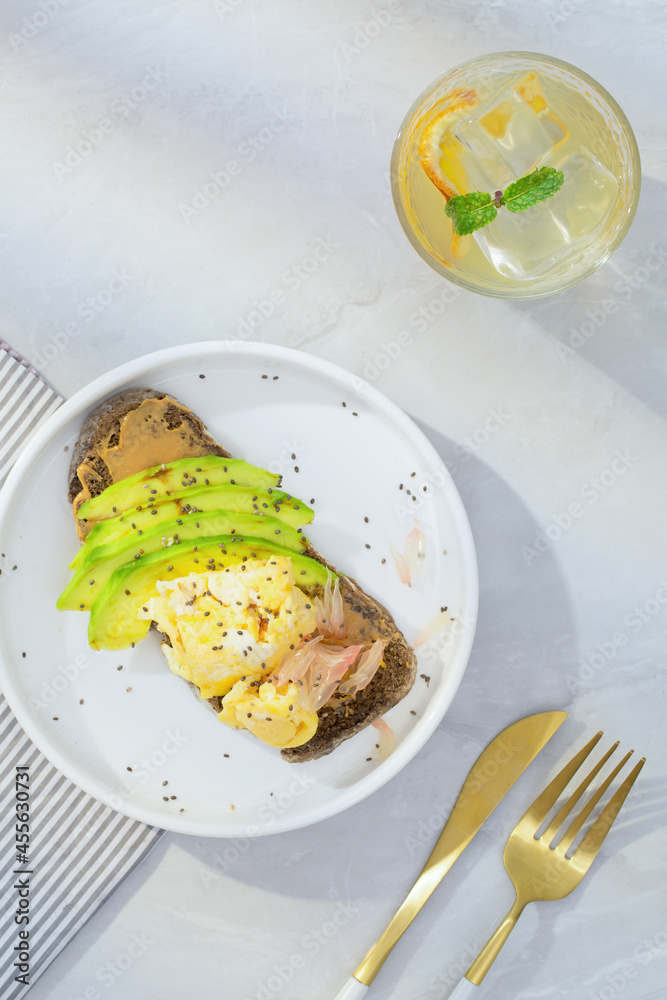 Avocado on toast with fresh thyme, lemon, and black sesame seeds and Lemon juice is good for health. Top view Avocado on toast with fresh thyme, lemon, and black sesame seeds and Lemon juice is good for health. Top view