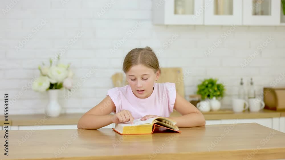 girl reading a book while sitting in the kitche girl reading a book while sitting in the kitche