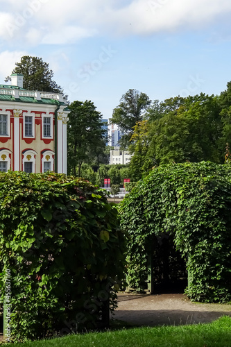 Green bushes in Park Kadriorg on a summer day. Red and white Barocco facade. New modern city on the back. Tallinn, Estonia, Europe. August 2021