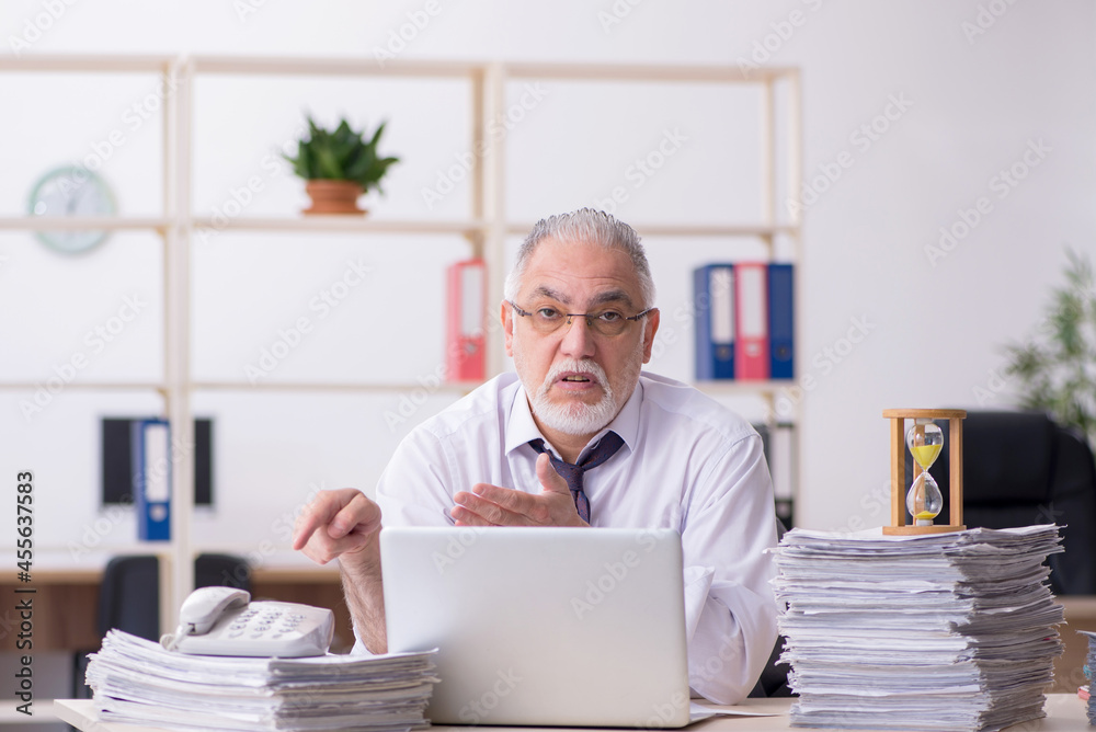 Old male employee in time management concept Old male employee in time management concept