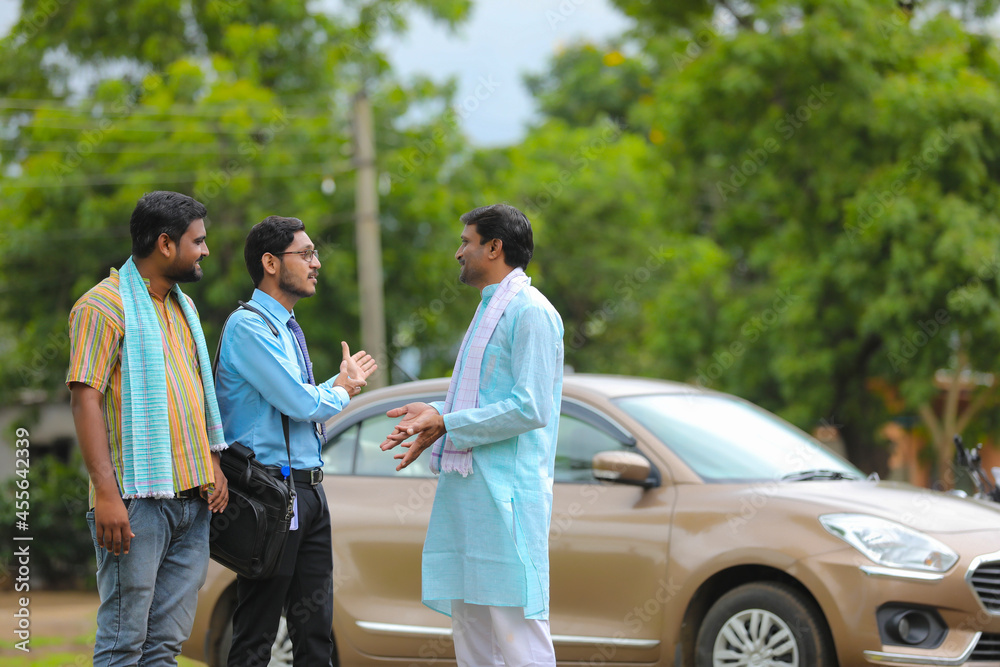 Vehicle loan concept: Young indian banker and farmers standing with new car Vehicle loan concept: Young indian banker and farmers standing with new car
