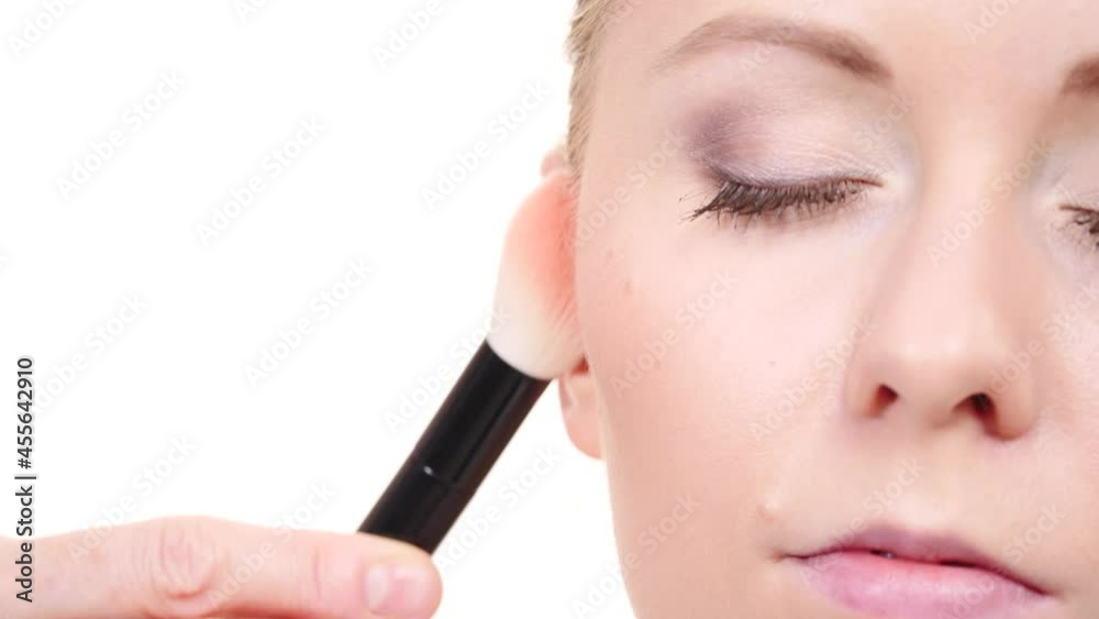 Woman face painting. Makeup artist applying blush bronzer with brush to model cheek. Cosmetic beauty procedures and makeover concept. Slow motion Woman face painting. Makeup artist applying blush bronzer with brush to model cheek. Cosmetic beauty procedures and makeover concept. Slow motion