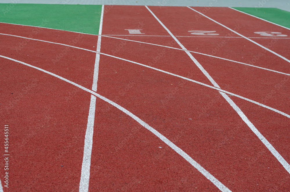 Running tracks with artificial turf. Red tracks in the stadium with a coating of crumb rubber. Sports field. Sports, active lifestyle. Selective focus.