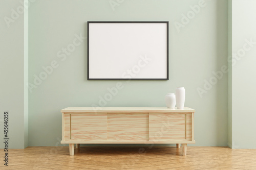Black horizontal poster frame mockup on wooden table in living room interior on empty pastel color wall background. 3D rendering. © CreatifyStudio