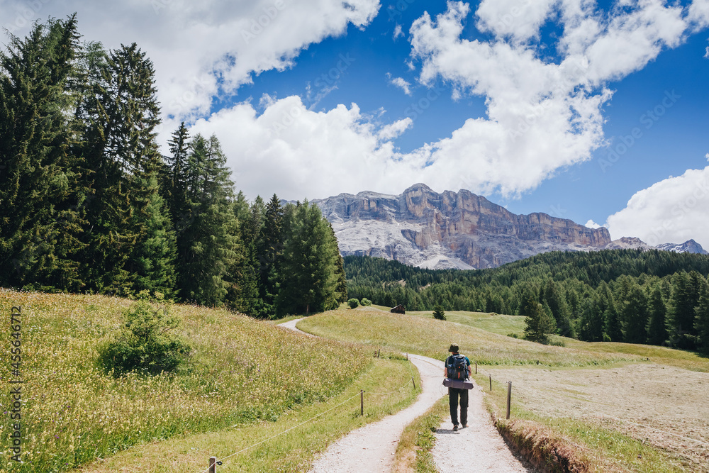 Man traveler with breathtaking landscape of Dolomites Mounatains in summer, Italy. Travel Lifestyle wanderlust adventure concept