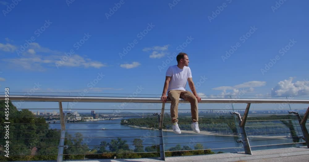 Tracking shot of a guy sitting on the railing of the glass bridge against backdrop of city. Caucasian guy sits on a narrow metal pipe. Concept of lost hope and suicide. There is always a way out
50 Tracking shot of a guy sitting on the railing of the glass bridge against backdrop of city. Caucasian guy sits on a narrow metal pipe. Concept of lost hope and suicide. There is always a way out
50