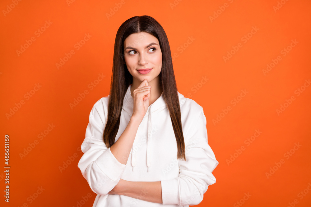 Portrait of attractive cheerful curious girl deciding copy empty space isolated over bright orange color background Portrait of attractive cheerful curious girl deciding copy empty space isolated over bright orange color background