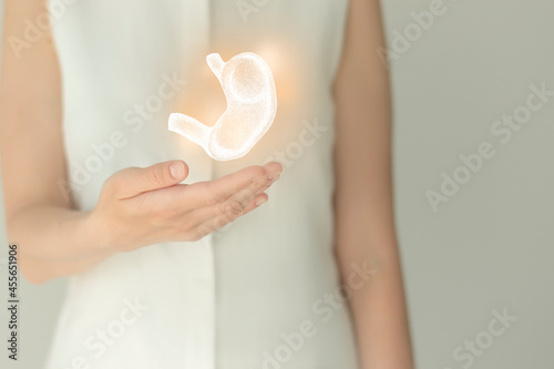 Woman in white clothes holding virtual stomach in hand. Handrawn human organ, detox and healthcare, healthcare hospital service concept stock photo
