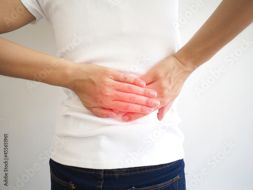 Woman back pain and lumbar pain caused by pyelonephritis, kidney stones, polycystic kidney disease, glomerulonephritis and Chronic renal failure. healthcare concept. closeup photo, blurred.