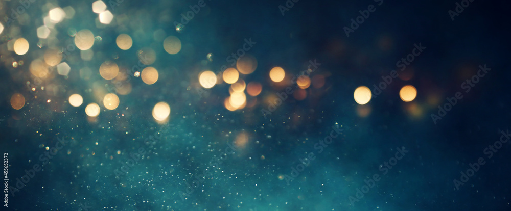 background of abstract glitter lights. gold, blue and black. de focused. banner