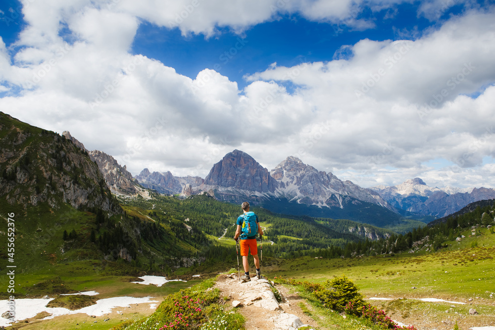 Man traveler with breathtaking landscape of Dolomites Mounatains in summer, Italy. Travel Lifestyle wanderlust adventure concept