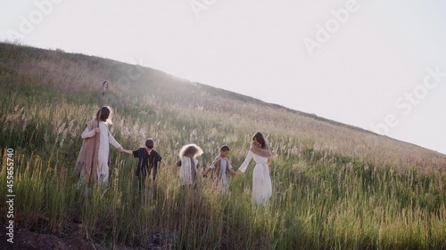 Jesus with the children and Mary is walking up the hill, the ears are swaying, the sun is shining. High quality 4k footage