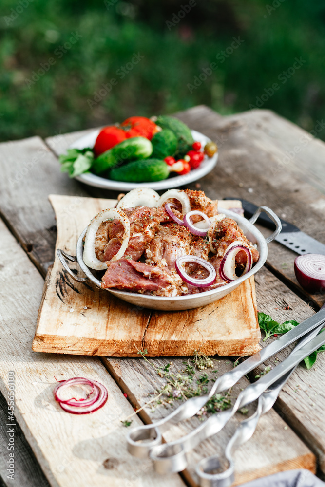 Marinated pork for shish kebab in an iron micron. Raw meat Marinated pork for shish kebab in an iron micron. Raw meat