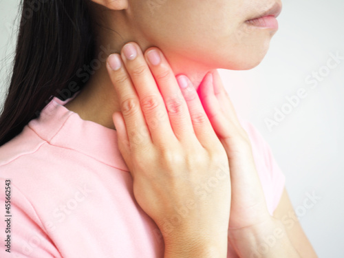 Woman suffering from sore throat on white background. closeup photo, blurred.