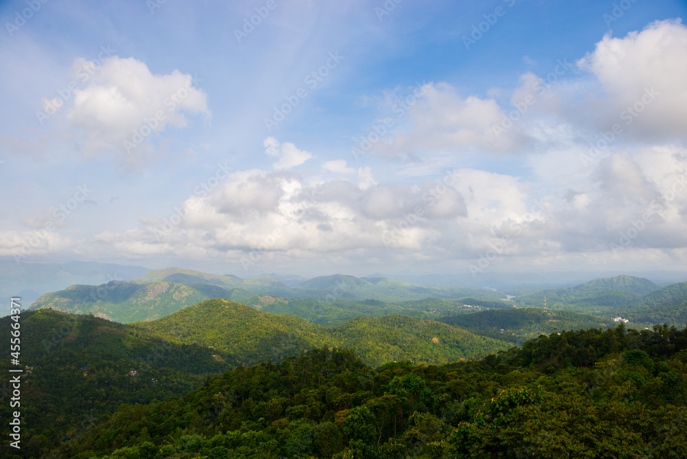 Spectacular view of a lush green mountains and beautiful clouds during monsoon. A scenic site from Munar, Kerala, India.
