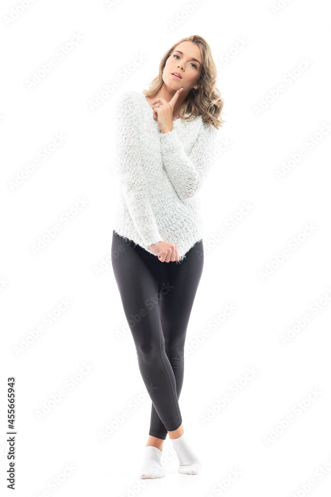 Puzzled young skeptical beauty in cozy home wear looking at camera with finger on cheek. Full-length portrait isolated on white background Puzzled young skeptical beauty in cozy home wear looking at camera with finger on cheek. Full-length portrait isolated on white background