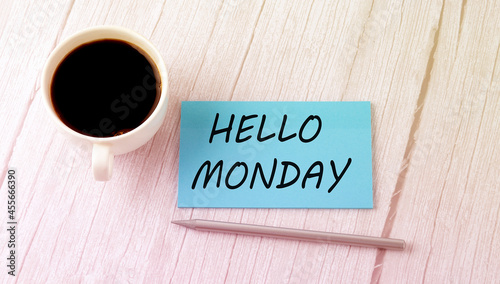 HELLO MONDAY text on the blue sticker with cofee and pen