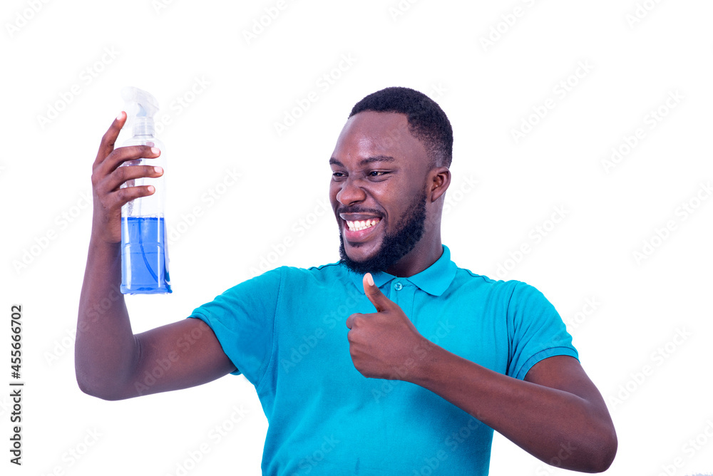 handsome happy young man holding a bottle of cleaning fluid and showing his thumb. handsome happy young man holding a bottle of cleaning fluid and showing his thumb.