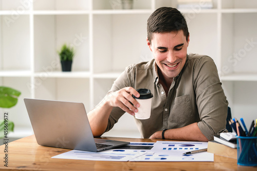confident young businessman Work from home with laptop and documents on the desk.