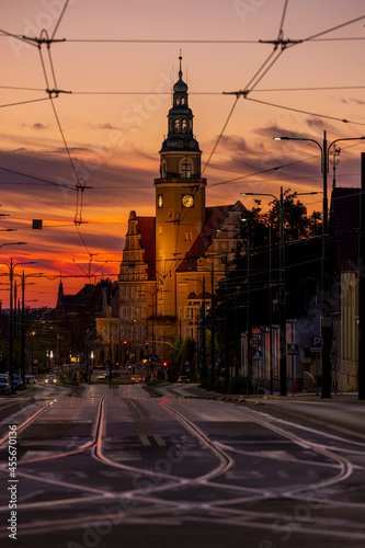 New Town Hall in Olsztyn and Piłsudskiego Street with tracks and electrification lines of city trams, view after sunset