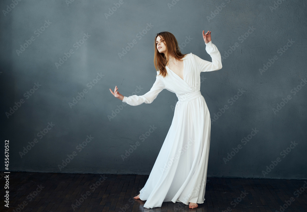 Woman in white dress barefoot dance fun dark background Woman in white dress barefoot dance fun dark background