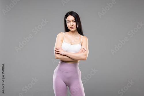 A young woman poses in sportswear on a white background