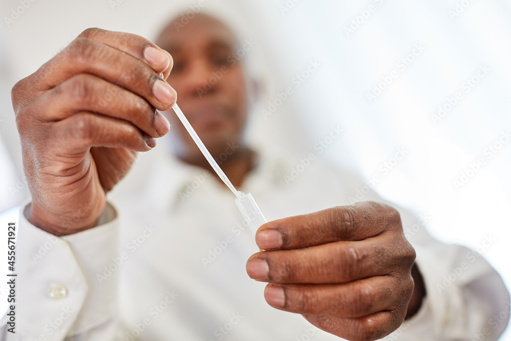 Man does a Covid-19 antigen test with a saliva sample Man does a Covid-19 antigen test with a saliva sample