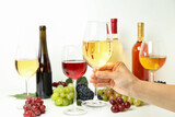 Female hand holds glass of white wine against various wines