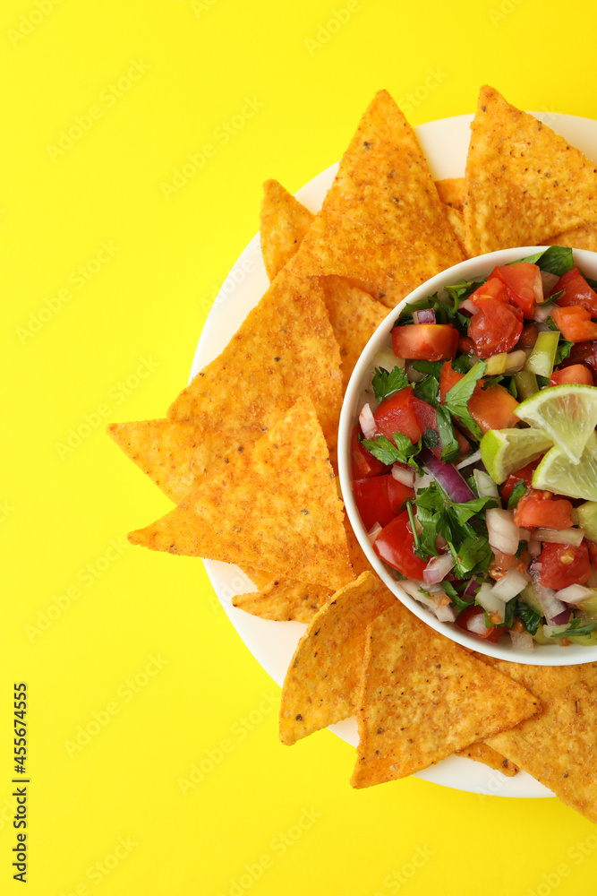 Pico de Gallo and chips on yellow background Pico de Gallo and chips on yellow background