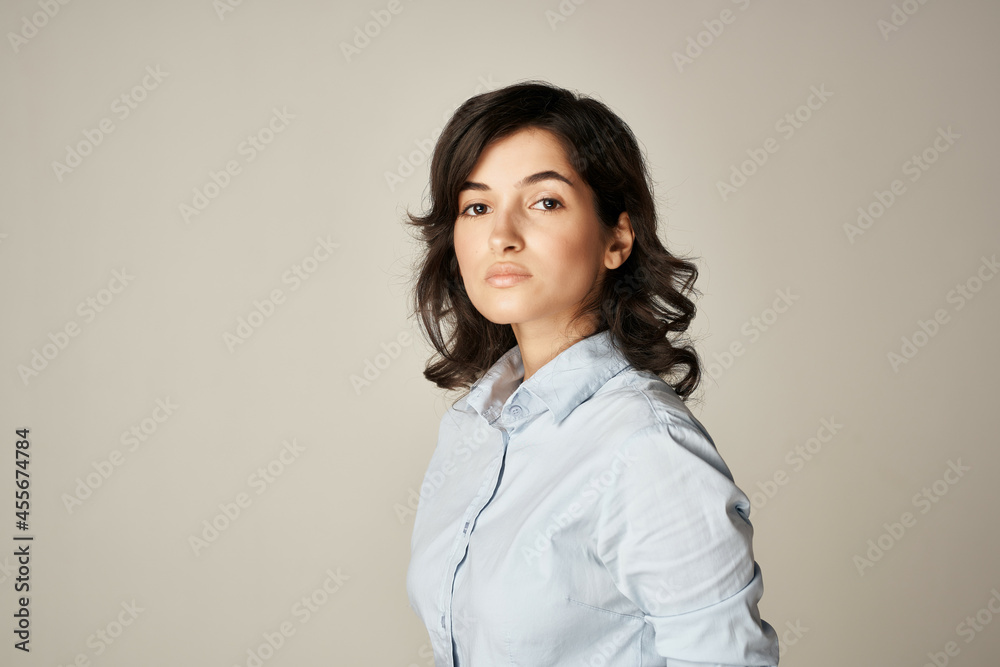 brunette in blue shirt cropped view light background elegant style